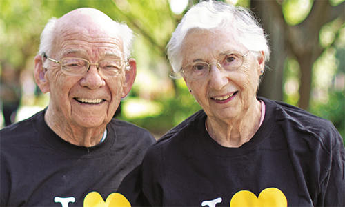 Two UCF alumni smile with I Love UCF t-shirts on