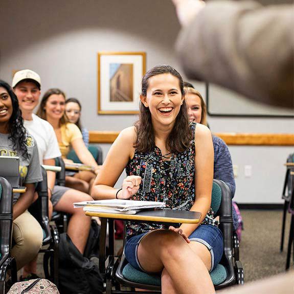 Student smiling in full classroom of students