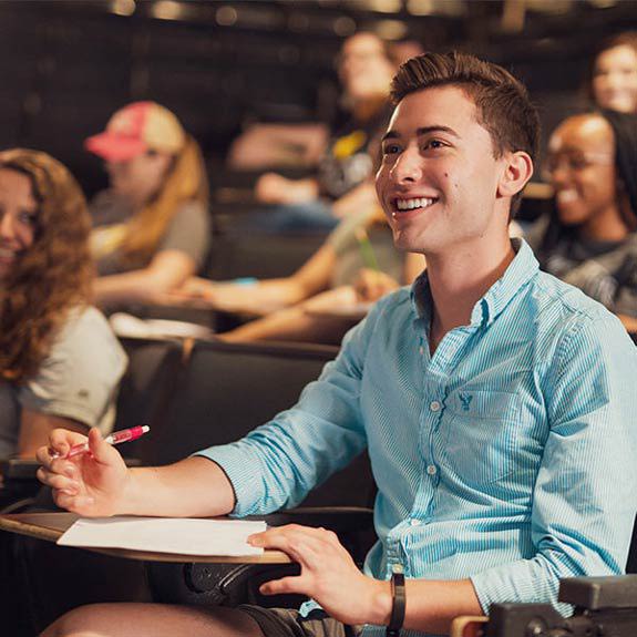 student smiling in a lecture hall class