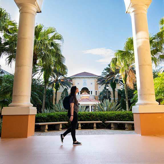 student walking past the Rosen College pavilion