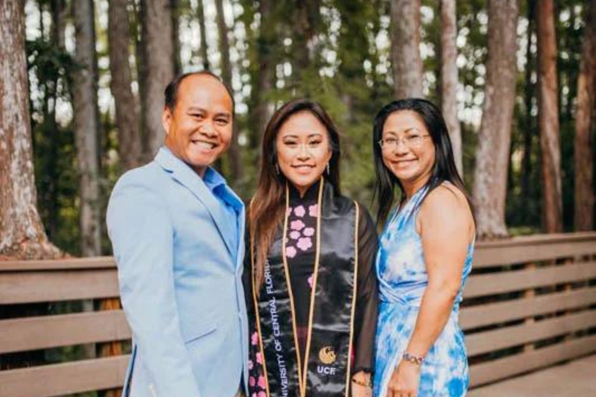 UCF student Theresa Kieu stands on the boardwalk at UCF in the middle of her parents