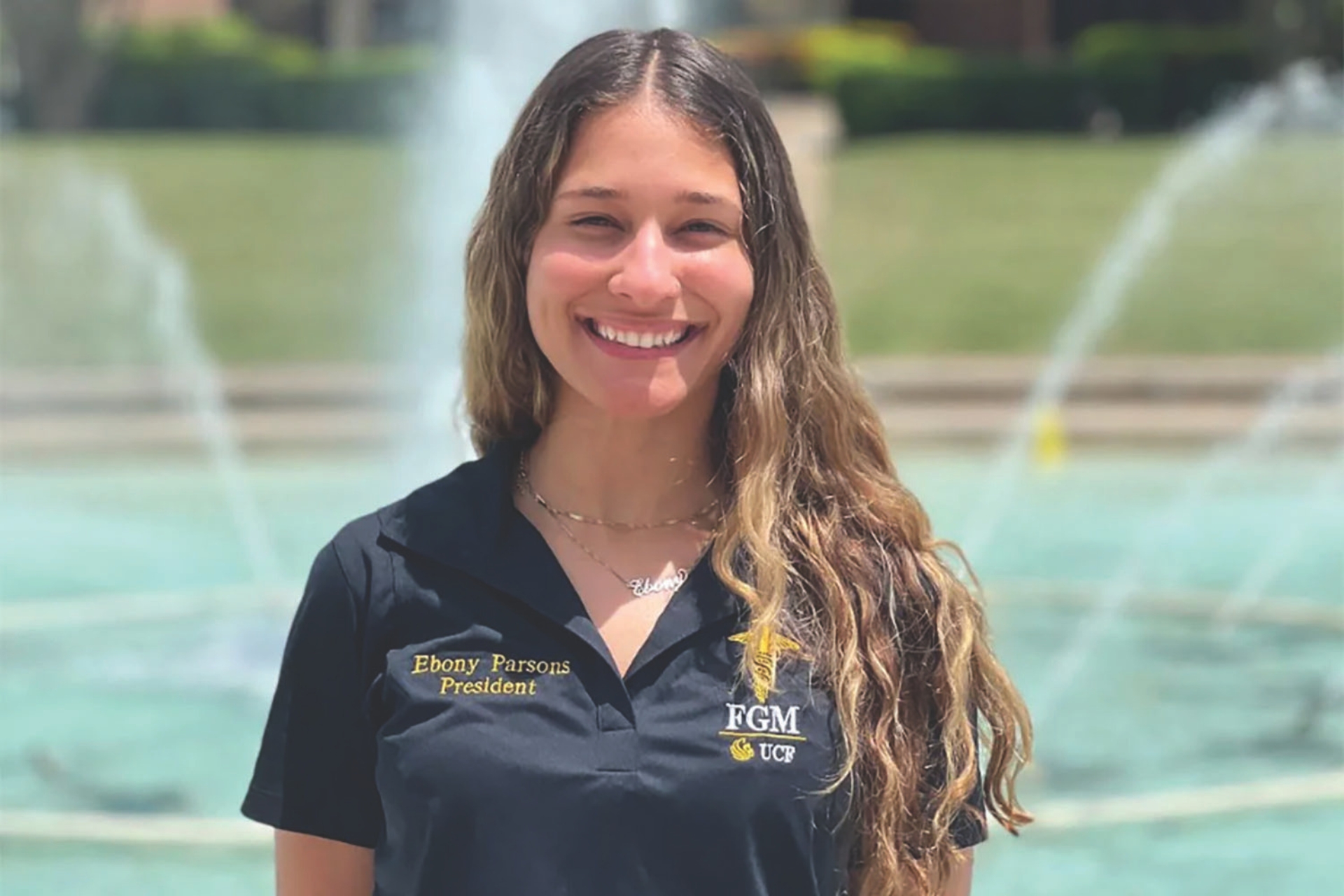 Ebony Parsons in a black UCF polo in front of the UCF Fountain 