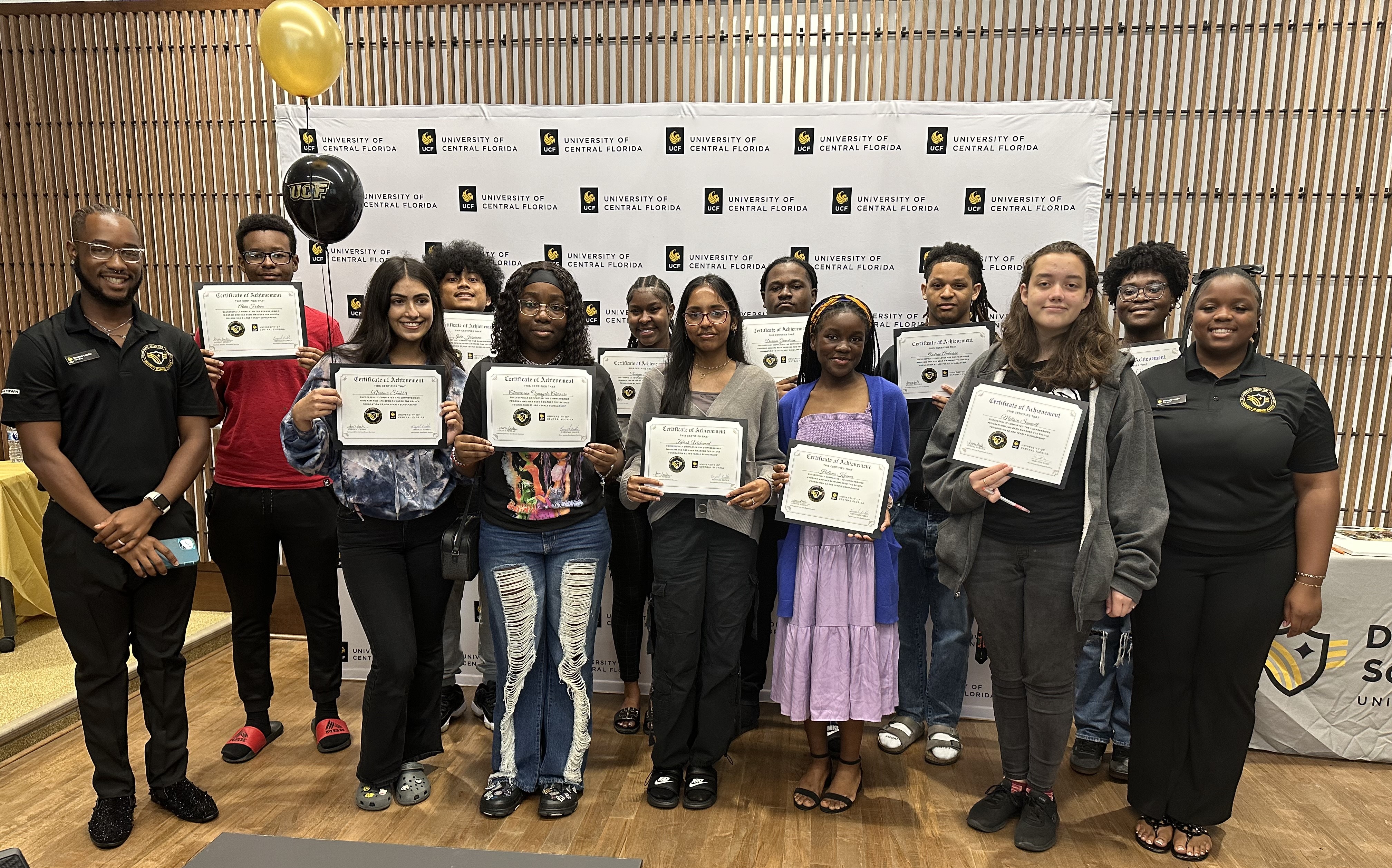 image-20240731-181726-a1bfb81f (1) UCF DSI Program student participants stan din front of a UCF step and repeat holding certificates